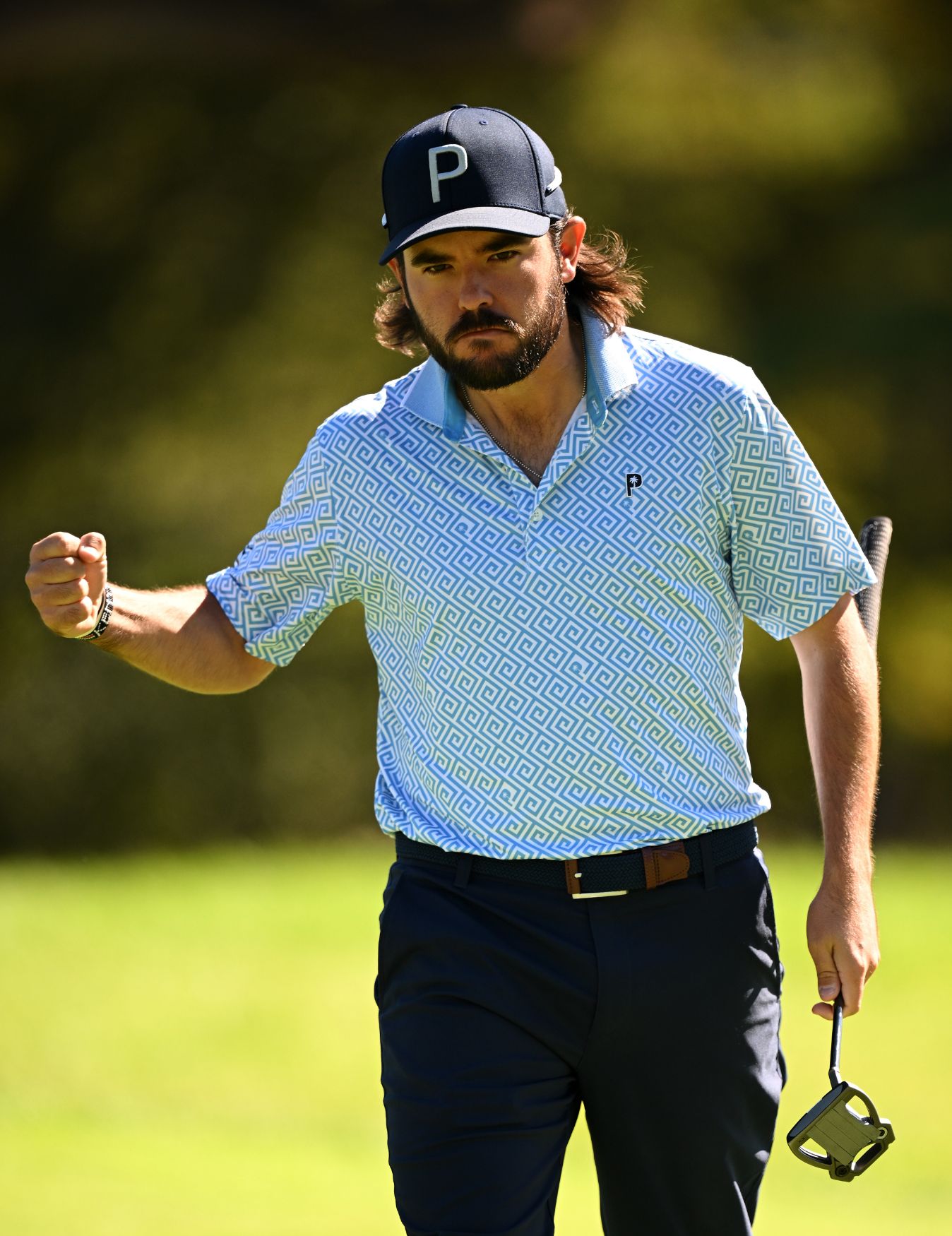 Ángel Hidalgo in Siegerpose mit einem Golfschläger.