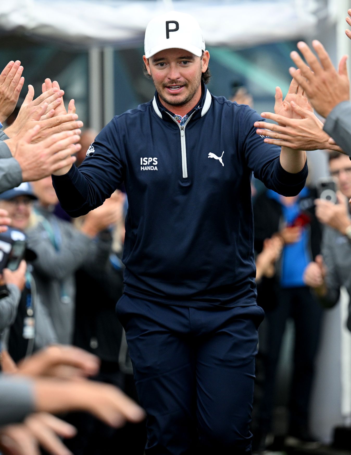 Ewen Ferguson runs by people victoriously and claps his hands.