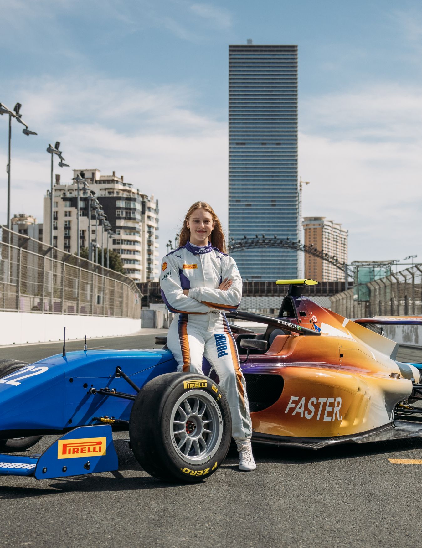 Aurelia Nobels sits on a racing car, against an urban backdrop.