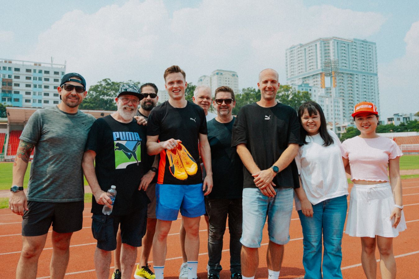 Romain Girard and Karsten Warholm among other people holding PUMA shoes.