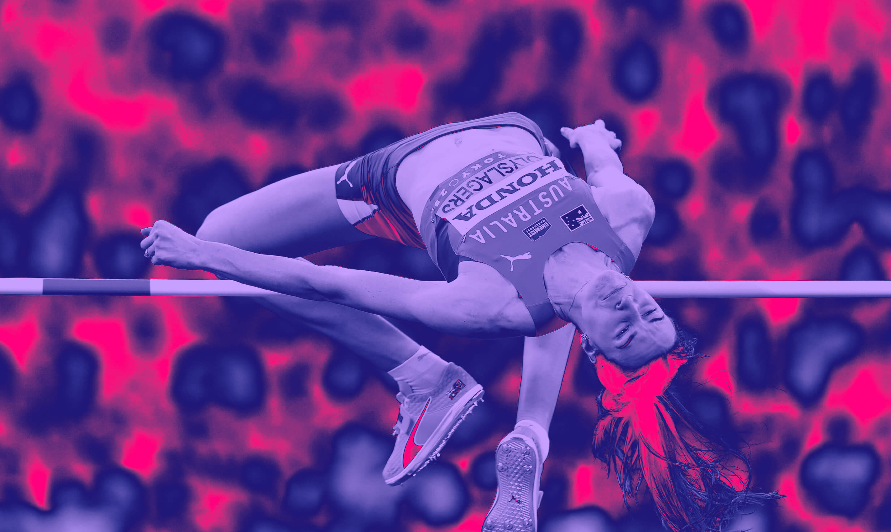 Australian high jumper Nicola Olyslagers clears the bar backward in the stadium, wearing orange Puma shoes during competition